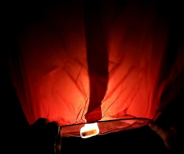 Peaceful person sitting in meditation against dark background